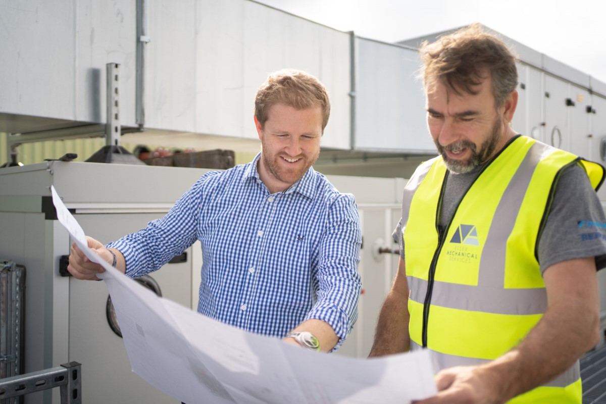 Two workers viewing and reading a building plan